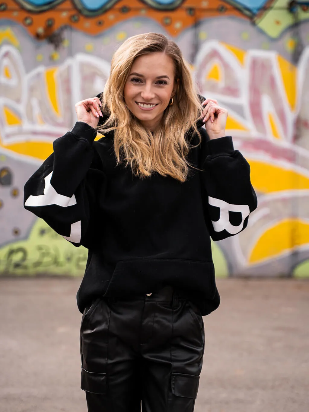 Meli, Gründerin und Trainerin von MMotion, vor einer Graffiti-Wand